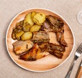 Lunch is served on plate - pieces of young rabbit baked with slice of potato. Close-up Royalty Free Stock Photo