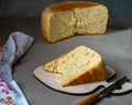 Portion of homemade grain on a kitchen board and round bread in a cut on a wooden table