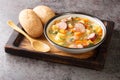 Portion of hot pea soup with potatoes, onions, carrots, bacon and sausages close-up in a bowl. Horizontal Royalty Free Stock Photo