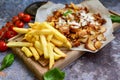 Portion of kebab Chicken duner gyros with french fries and garlic sauce on wooden board Royalty Free Stock Photo