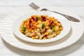 portion of mac and cheese with corn, bacon topped with panko breadcrumbs on white plate on white wooden table Royalty Free Stock Photo