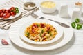 portion of mac and cheese with corn, bacon topped with panko breadcrumbs on white plate on white wooden table Royalty Free Stock Photo