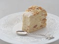 Portion of multi layered cake, cut off with funny spoon. Puff pastry cake decorated with crumbs