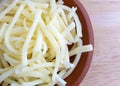 Portion of natural white mild cheddar cheese in bowl