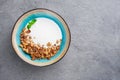 Portion of Natural yogurt with homemade cereal granola in blue bowl