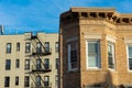 A Portion of an Old Brownstone Townhouse and a Residential Building with a Fire Escape in the Background in Astoria Queens of New