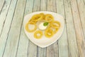 Portion of onion rings battered and fried in olive oil accompanied by aioli