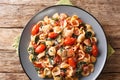 Portion of orecchiette pasta with spinach in tomato sauce sprinkled with parmesan closeup in a plate. Horizontal top view Royalty Free Stock Photo