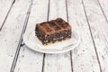 Portion of oreo brownie cake on white napkins on a white plate