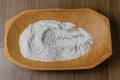 Portion of raw whole wheat flour, wooden bowl, wooden table top view Royalty Free Stock Photo