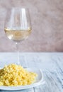 Portion of risotto with glass of white wine