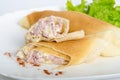 Portion of rolled pancakes or crepes cut in half stuffed with ham and cheese on oval dishes served salad Royalty Free Stock Photo