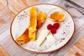 Portion of rolled pancakes with raspberries, honey and pieces of cheese