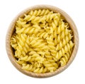 Portion of Rotini corkscrew pasta in wooden bowl. Uncooked dried durum wheat semolina