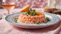 portion of salmon risotto in an embroidered plate on a pink tablecloth