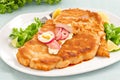 Portion of schnitzel with garnish on white background