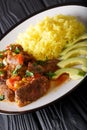 Portion of seco de chivo stewed goat meat with yellow rice and a