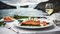 portion of smoked salmon steak and asparagus in a white plate on a white tablecloth in front of Icelandic waterfalls