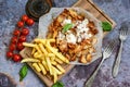 Portion of kebab Chicken duner gyros with french fries and garlic sauce on wooden board Royalty Free Stock Photo