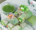 Portion of spring rolls on old wood with spicy sauce, vegetables Royalty Free Stock Photo
