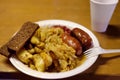 Portion stewed cabbage, fried potatoes and sausages in a disposable plate on famous Christmas fair in Tallinn
