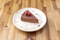 Portion of sweet potato cake like chocolate simile with some raspberries on a wooden table Royalty Free Stock Photo