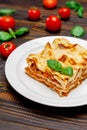 Portion of tasty lasagna on wooden backgound