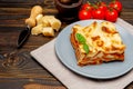 Portion of tasty lasagna on wooden backgound