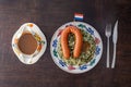 Portion of traditional dutch \'Boerenkool stamppot met worst\' potatoes mashed with kale, smoked sausage and gravy Royalty Free Stock Photo