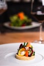 A portion of vegetables and herbs on a crunchy base, served on a plate, the concept of fine dining