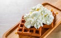 Portion of Viennese wafers with cream and ice cream on wooden table