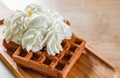 Portion of Viennese wafers with cream and ice cream on wooden table