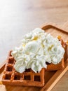 Portion of Viennese wafers with cream and ice cream on wooden table