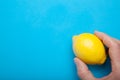 Portion of vitamins in the hand - yellow lemon on a blue background