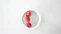 A portion yoghurt with frozen strawberries for diet on a white background