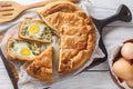 Portioned traditional Italian Easter cake or tart with spinach, ricotta and whole eggs closeup on the wooden board. Horizontal top Royalty Free Stock Photo