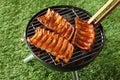 Portions of spicy spare rib grilling on a barbecue