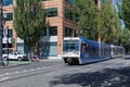 A Trimet light rail train heading through a city near Skidmore Fountain district, Portland, Oregon