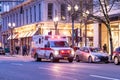 American Medical Response ambulance unit with lights on of a street of downtown