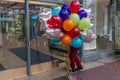 Portland, Oregon, USA, January, 16, 2016: A man entering an open door to a shopping mall loaded with a large bunch of brightly