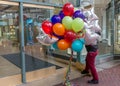 Portland, Oregon, USA, January, 16, 2016: A man about to enter a shopping mall loaded with a large bunch of brightly coloured