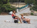 Porto Germeno, Greece. October 2020:  Two elderly women and a small dog on beautiful beach Agios Nikolaos in the Corinthian Gulf o Royalty Free Stock Photo