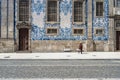 Porto, Portugal - April 4, 2017: Woman walking in front of a tiled facade of Igreja do Carmo in P