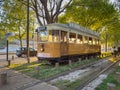 PORTO, PORTUGAL - 11 APRIL 2023: Wooden historical vintage yellow tram passing by in Massarelos with the Arrabida bridge in the