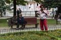 Porto, Portugal - 09/16/2019: Artist guy dressed in red and white. Two ladies talking in the background. City of Porto