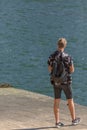 Back view of teenager, by the river, enjoying the view