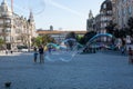 Porto, Portugal - 08/28/2019: Big soap bubbles and Porto city in the background. People waching. Aliados Avenue