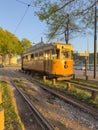 PORTO, PORTUGAL - CIRCA APRIL 2023: Wooden historical vintage yellow tram 287 moving on Porto street, symbol of city. Old tram Royalty Free Stock Photo