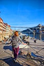 Porto, Portugal - 09 of December, 2018: Young woman traveler standing back enjoying beautiful cityscape view on Douro river,