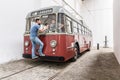 Porto, Portugal - 25.08.2019: guy stands on the bumper of an old red bus and yells through the windshield at the driver Royalty Free Stock Photo